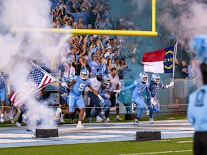 The UNC football team runs onto Chris Smith Field during the Homecoming game against Pitt at Kenan Stadium on Saturday, Oct. 29, 2022. UNC beat Pitt 42-24.