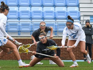 Graduate student attacker Sam Geiersbach (36) and junior midfielder Nicole Humphrey (9) attempt to grab a fallen ball in the game against Jacksonville University in Dorrance Field on Saturday, February 27, 2022.