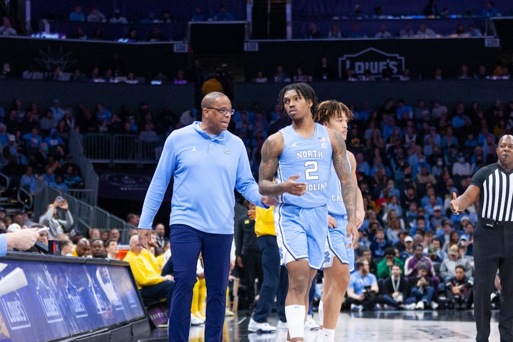 UNC head coach Hubert Davis guides junior guard Caleb Love (2) on the sidelines during the men's basketball game against Michigan at the Jumpman Invitational in Charlotte, N.C., on Wednesday, Dec. 21, 2022. UNC beat Michigan 80-76.