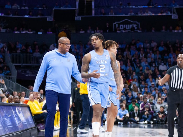 UNC head coach Hubert Davis guides junior guard Caleb Love (2) on the sidelines during the men's basketball game against Michigan at the Jumpman Invitational in Charlotte, N.C., on Wednesday, Dec. 21, 2022. UNC beat Michigan 80-76.