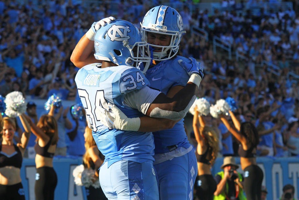 Elijah Hood (34) celebrates with a teammate after scoring a touchdown against James Madison. 