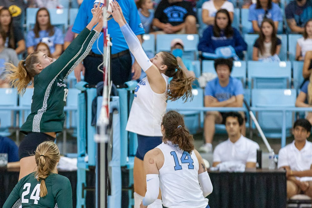 UNC freshman setter Anita Babic (12) blocks the ball during the volleyball match against Michigan State on Friday, Sept. 9, 2022, at Carmichael Arena.  UNC beat Michigan State 3-0.
