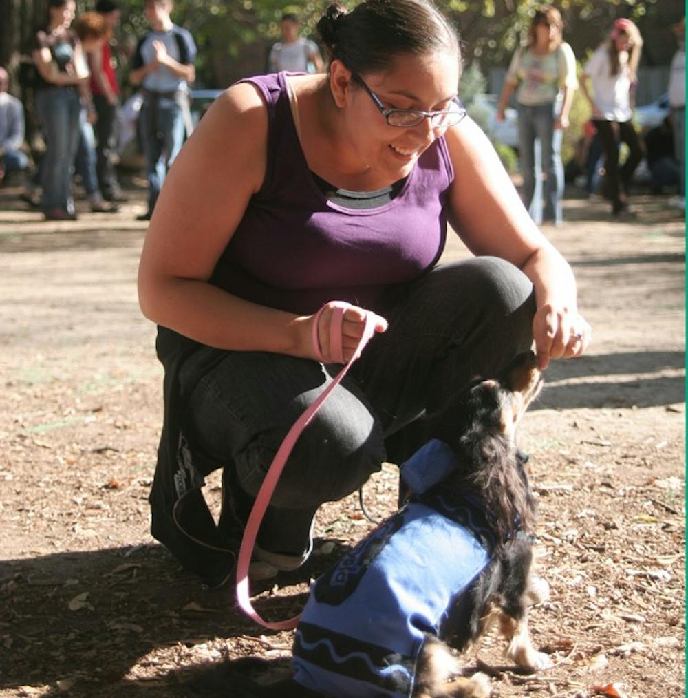 Kelly Alexandre of Chapel Hill leads her dog, Zelda, through the “musical sit” event at the 9th annual Carrboro Weiner Dog Day on Sunday.