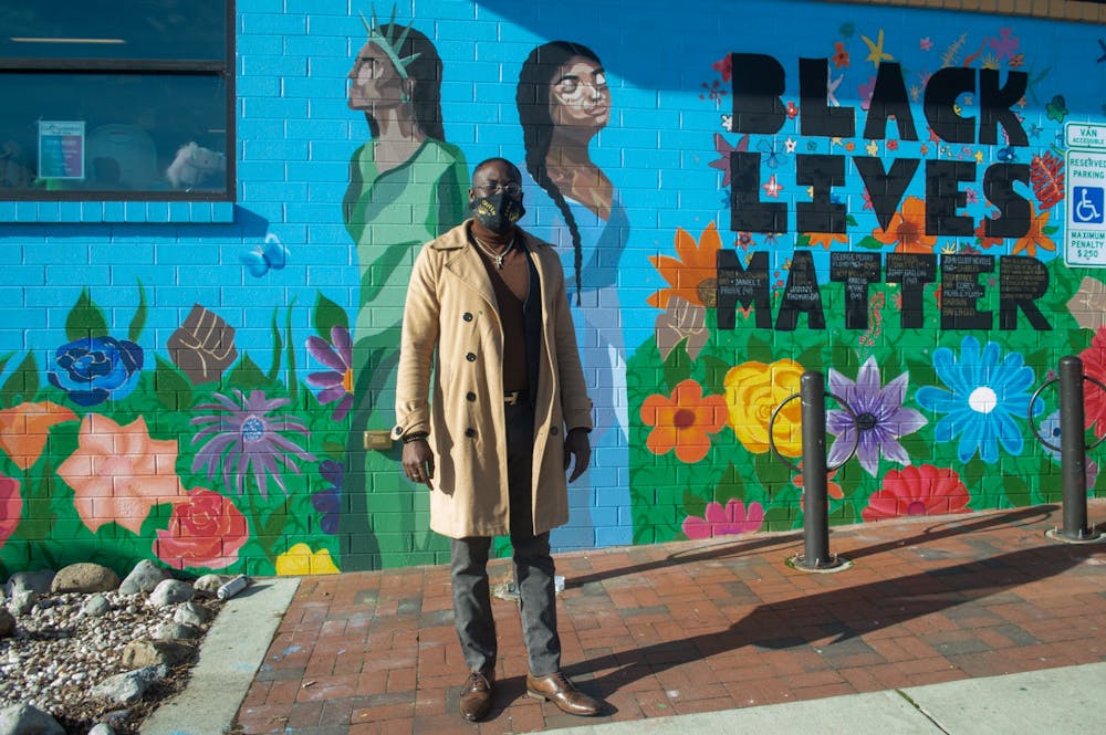 Ty Small, Coordinator of the Black Lives Matter Mural at the Community Worx building in Carrboro, stands in front of his work on Monday Jan. 11 2021.