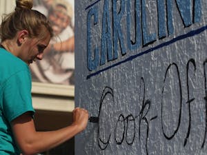 Kristen Wagner, the co-chair of the event, paints on one of the blocks in the pit in hopes of publicizing for the The Great Carolina Cook-Off.