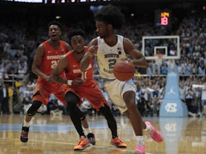 First-year guard Coby White dribbles past a Syracuse defender in the Smith Center on Tuesday, Feb. 26, 2019. White hit a new career high 34 points. UNC beat Syracuse 93-85.