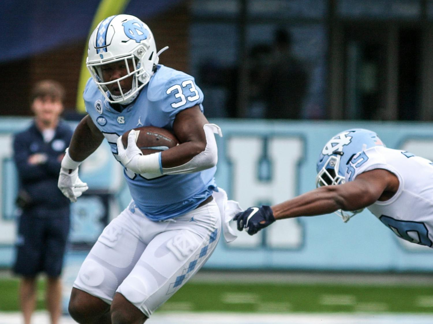 Redshirt freshman running back Kamarro Edmonds protects the ball in the Spring Game on Saturday, April 9, 2022. The Tar Heels and Carolina tied, 14-14.