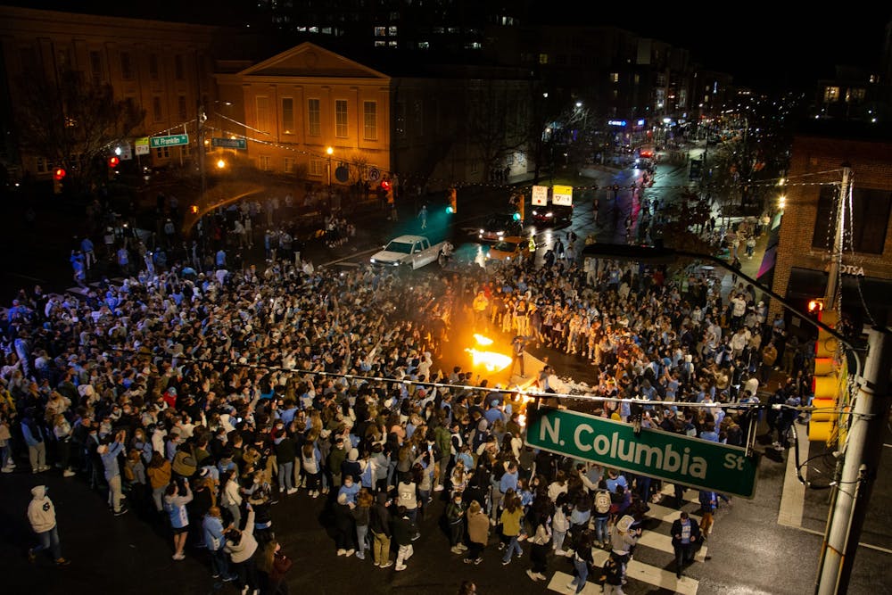 UNC fans rush Franklin Street  and light a mattress on fire after UNC's basketball team triumphs over Duke despite COVID-19 restrictions on Saturday, Feb. 6, 2021.