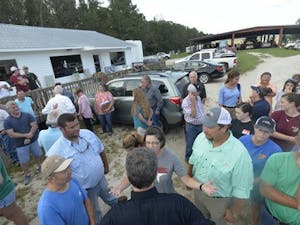 North Carolina Gov. Roy Cooper, foreground, back to camera, talks with farmers on Friday, Sept. 21, 2018, at a stop in Trenton, N.C., as he tours agricultural areas of the state hit hard by Hurricane Florence. (Scott Sharpe/Raleigh News & Observer/TNS)