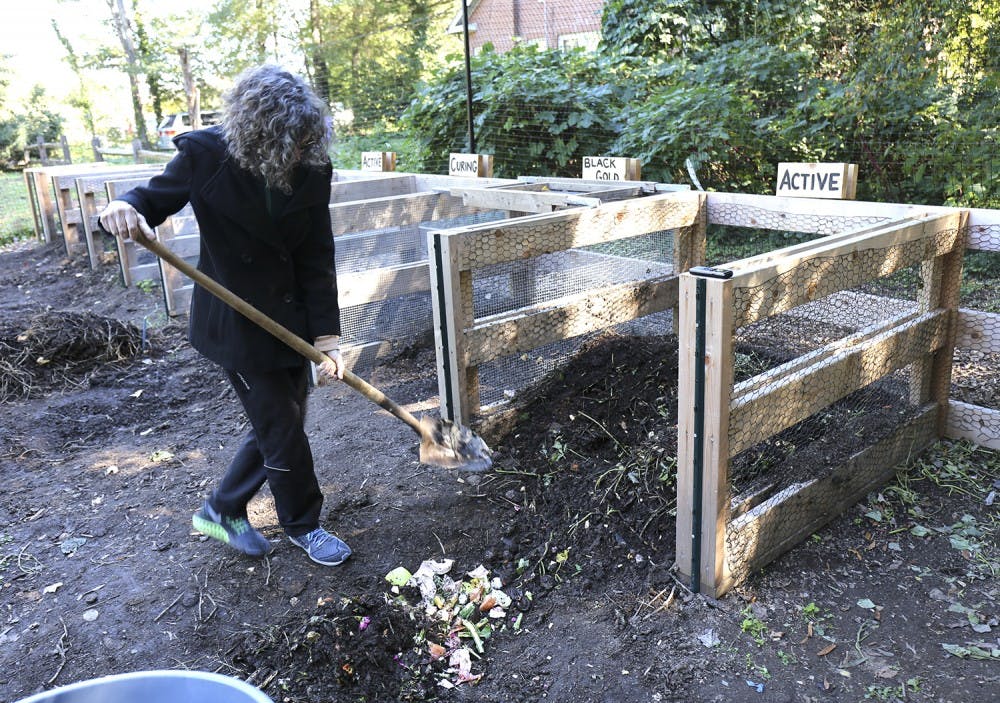 Claire Lorch, the garden manager and education coordinator for UNC’s community gardens, works on one of the newly constructed composts.