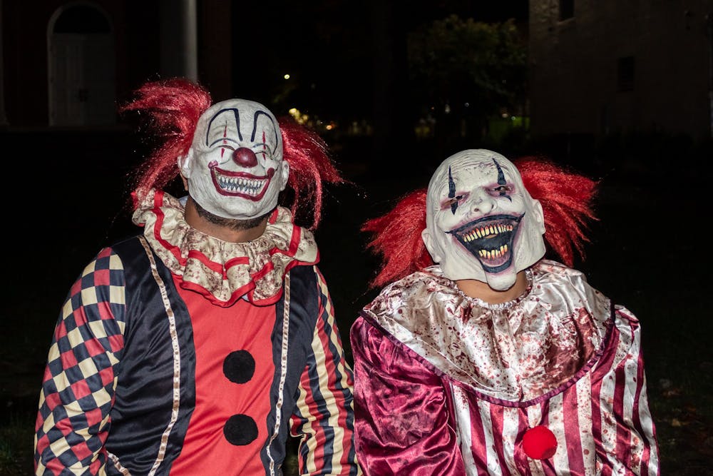 Two clowns smile for the camera during Halloween on Franklin Street on Monday, Oct. 31, 2022.