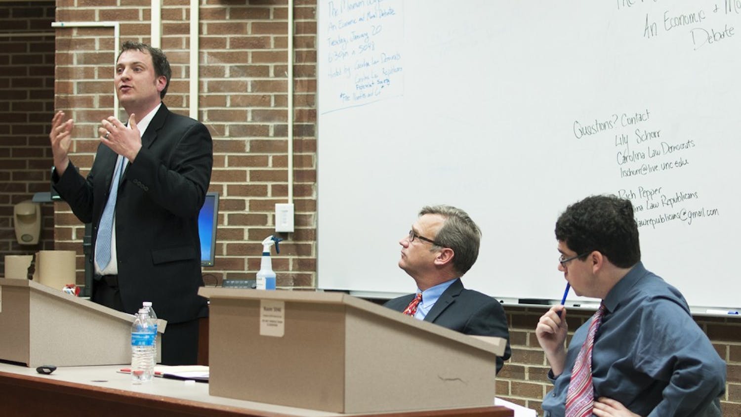 T. William Lester (left) and Adam Smith (right) debate the moral and economic impacts of possibly raising the federally mandated minimum wage at Van Hecke-Wettach Hall on Tuesday.