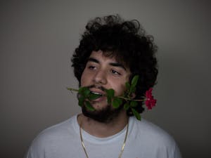 Sports Editor, PJ Morales, holds a flower in his mouth to recreate a photo of Drake.