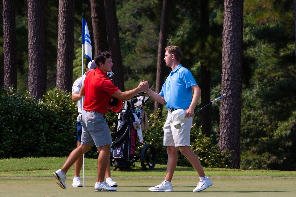 Senior Ryan Gerard shakes hands with his opponent after he won the Rod Myers Invitational at the Duke University Golf Club on Sept. 12, 2021.