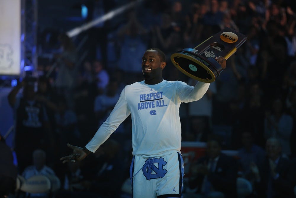 Theo Pinson presents the 2017 national championship trophy at Late Night With Roy on Friday night.