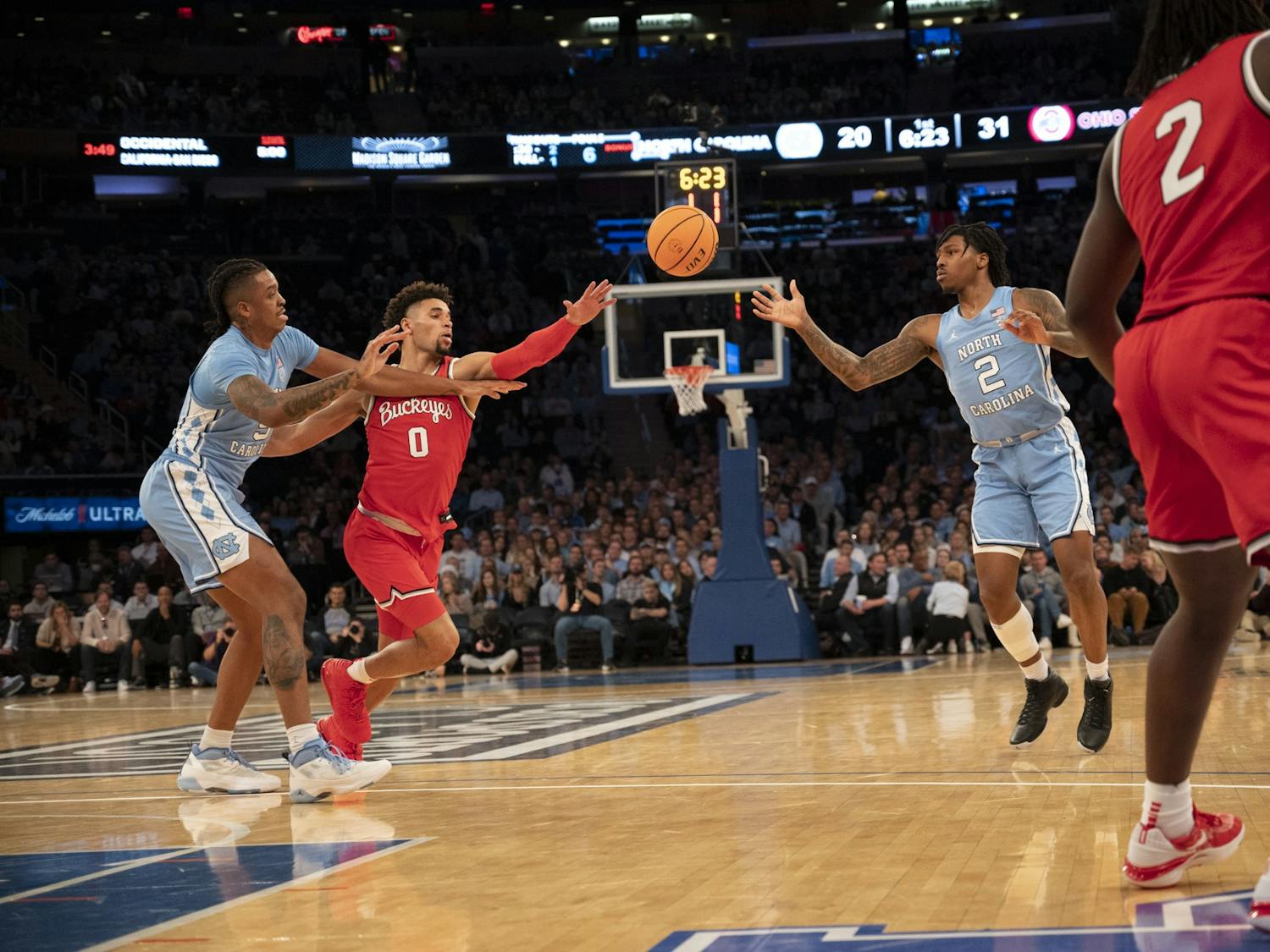 UNC senior forward/center Armando Bacot (5) tries to maintain UNC's possession passing the ball to UNC junior guard Caleb Love (2) during the men's basketball game against Ohio State at Madison Square Garden on Saturday, Dec. 17, 2022. UNC beat Ohio State 89-84.