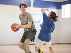 Ryan Wilcox (left) sports editor of The Daily Tar Heel, swivels past a staffer at Duke's Chronicle during a scrimmage in Brodie Recreation Center on Duke's campus on Sunday, Jan. 26, 2020. The Daily Tar Heel beat the Chronicle three games to one.
