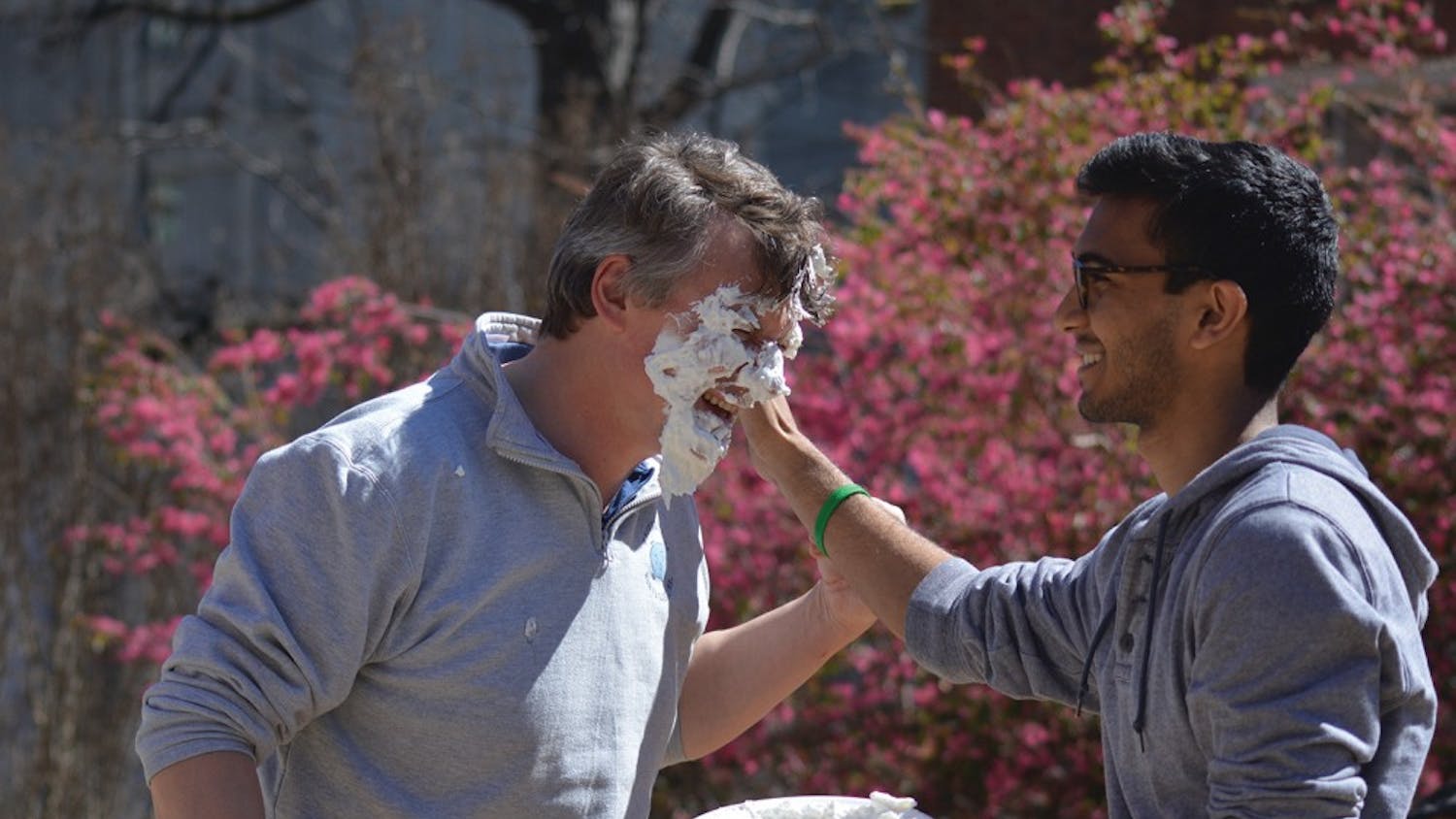 Jan-Michael Frahm (left) gets hit with a pie thrown by Sanjeev Prasada at a Pi Your Professor computer science fundraiser Wednesday afternoon.