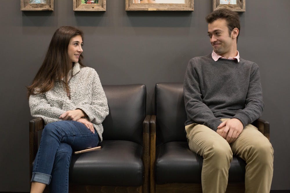 <p>Juniors Marigny Strauss (left) and Trent Martensen sit next to each other inside of the local coffee spot, Tama Tea, as they portray the awkwardness of asking another person on the first date.</p>