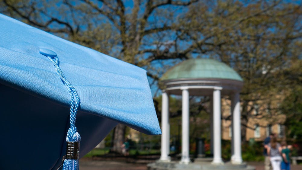 A Carolina blue graduation cap rests in front of the Old Well on Thursday, March 30, 2023.
