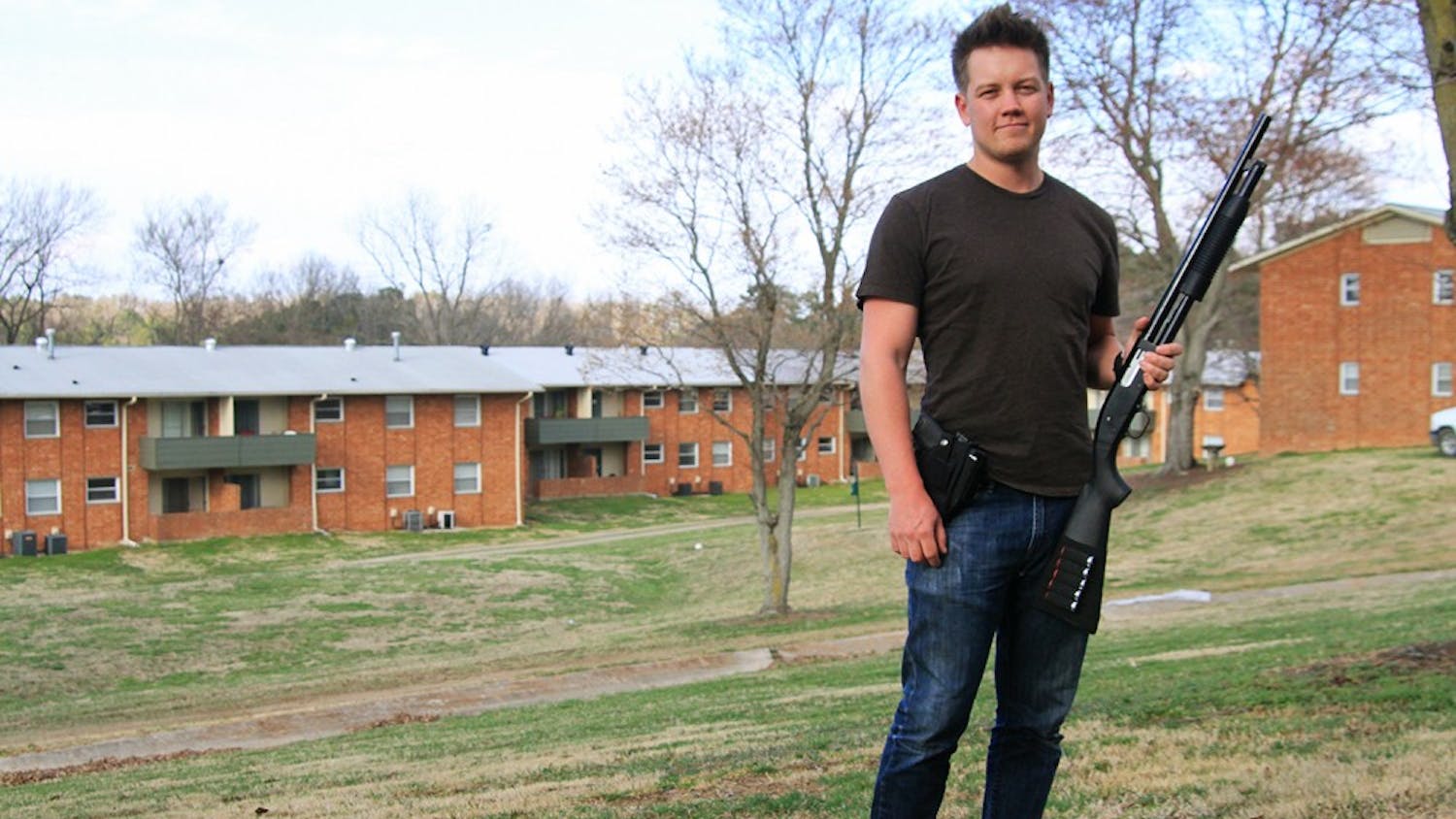 Senior mathematics major Thomas Rees holds his Mossberg 88 shotgun outside his apartment.