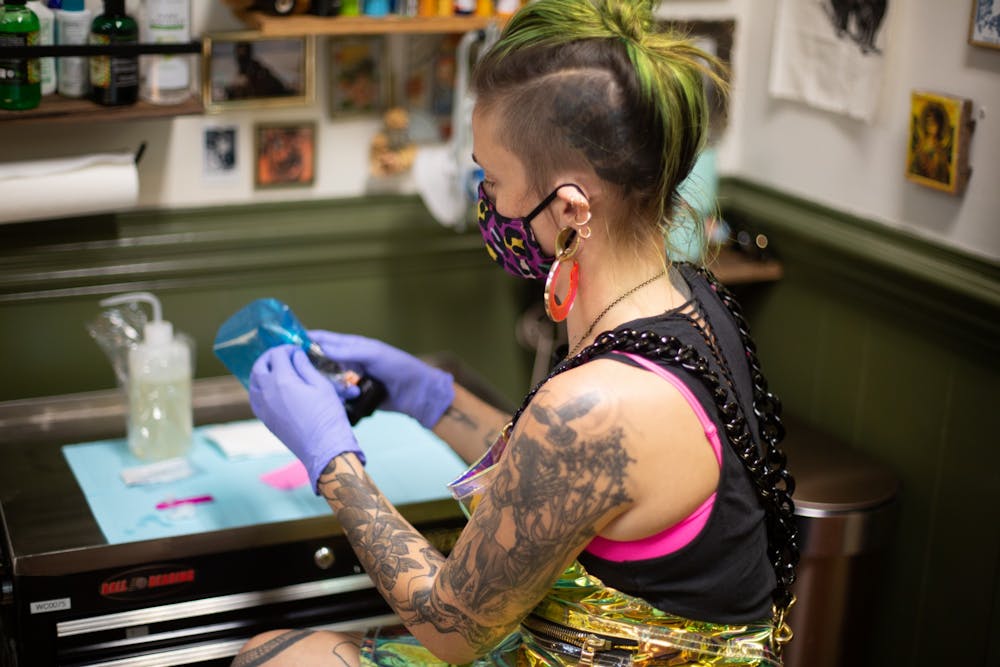 Ayden Love, a resident artist at Critter Swamp in Hillsborough, prepares to tattoo a client on Thursday, Oct. 29, 2020.
