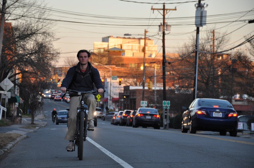 <p>UNC student George Ellington rides his bike down West Main Street in Carrboro.</p>