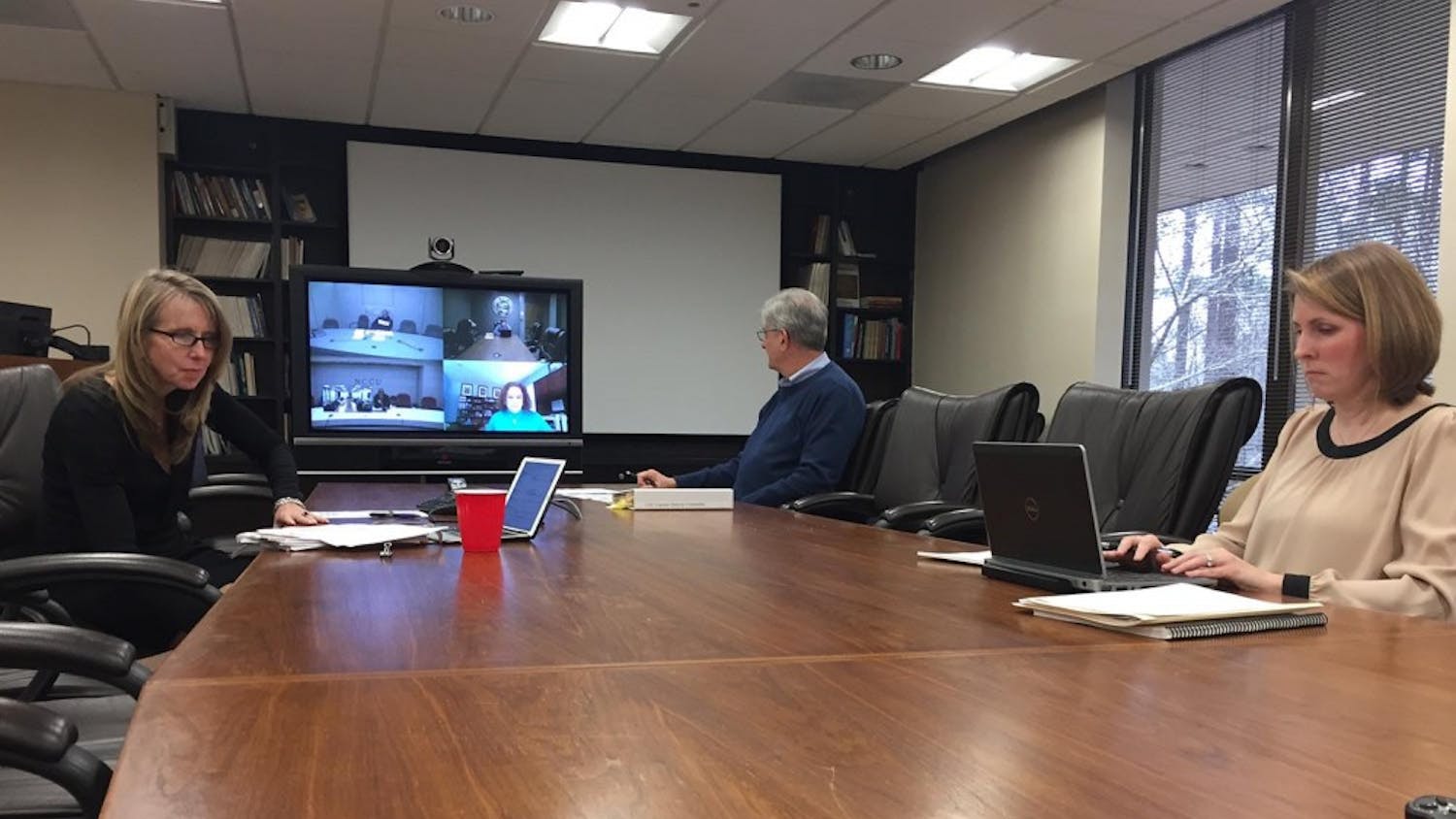 Jayne Grandes, Robert Joyce and Carrie Johnston (L-R) along with other subcommittee members discuss UNC system's policy on sexual harassment and sexual violence via teleconference. The subcommittee is part of the Board of Governor's Campus Security Committee.