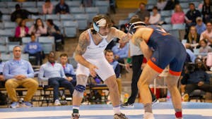 Graduate student Austin O’Connor faces off against his opponent during a wrestling match against UVA on Friday, Jan. 27, 2023, in Carmichael Arena. UNC won 30-9.