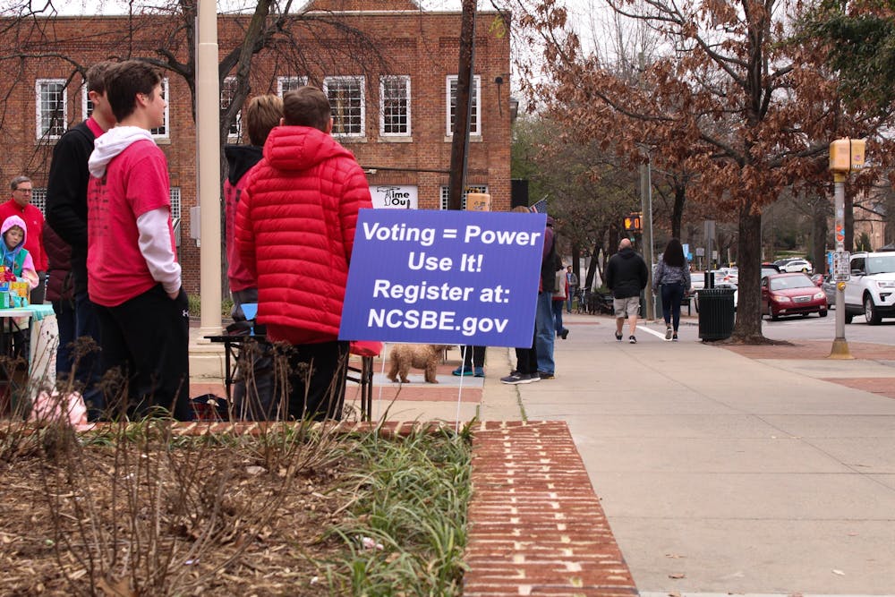 Volunteers in Chapel Hill offer voter registration assistance on Feb. 9, 2020 in front of the post office on Franklin Street. North Carolina and Orange County are continually focusing on improving the voting process for the upcoming primaries.