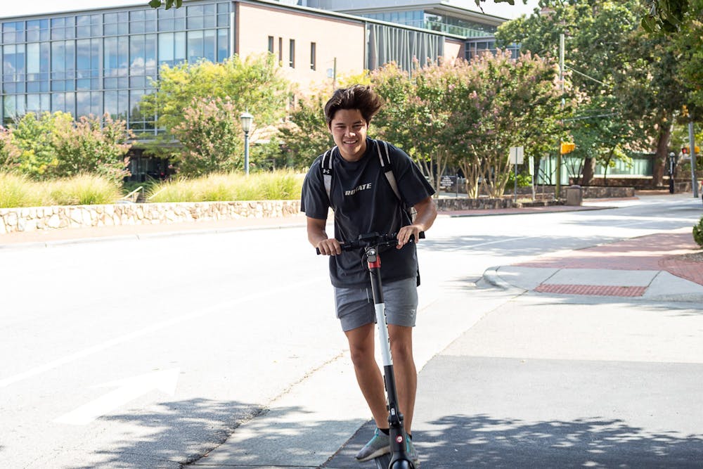 UNC junior Jonpaul Escobal rides his electric scooter down Pittsboro Street in Chapel Hill, N.C. on Friday, Sept. 9, 2022.