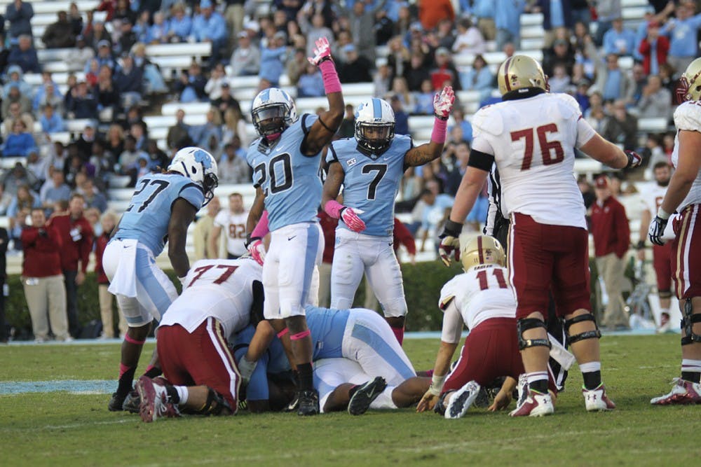 	UNC&#8217;s Brandon Ellerbe (20) and Tim Scott (7) motion for possession of the ball after UNC recovered the fumble.