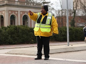 Joann Isom direct pedestrian and vehicle traffic every morning in front of the bell tower to help students get safely to and from class.