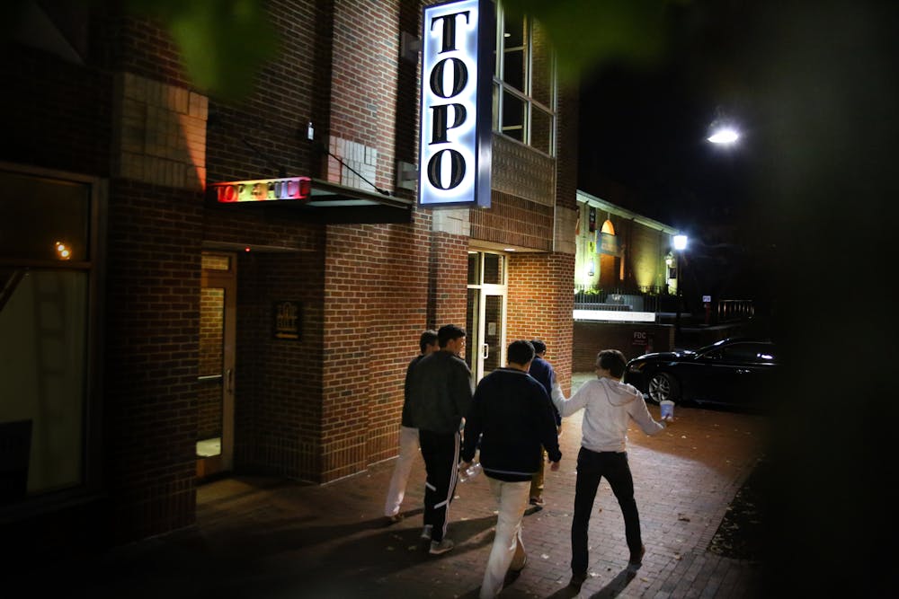 <p>UNC students walk pass Top Of The Hill restaurant and brewery in Chapel Hill Monday night. &nbsp;</p>