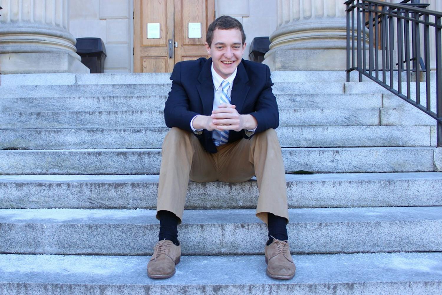 John Taylor sits on the steps of Wilson Library, one of his favorite places on campus. Taylor is currently running for student body president. 