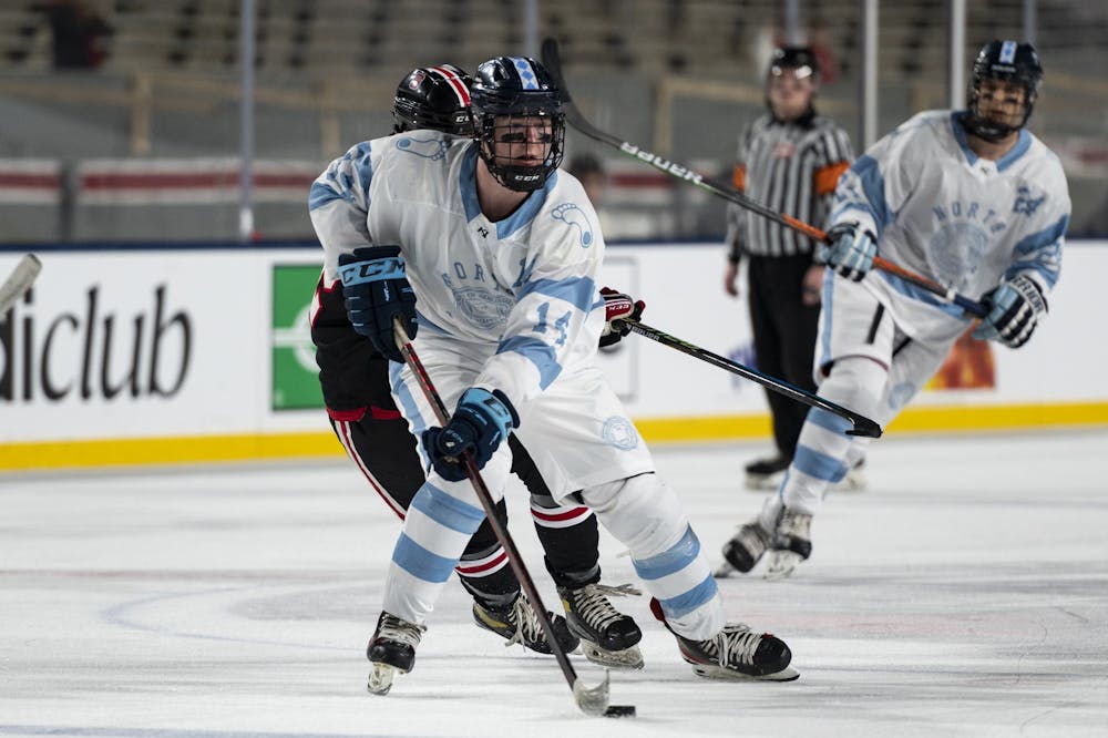 <p>UNC forward Patrick O'Shaughnessy (14) transitions the puck across the rink during the ice hockey game against N.C. State at Carter-Finley Stadium on Monday, Feb. 20, 2023. UNC lost 3-7.</p>