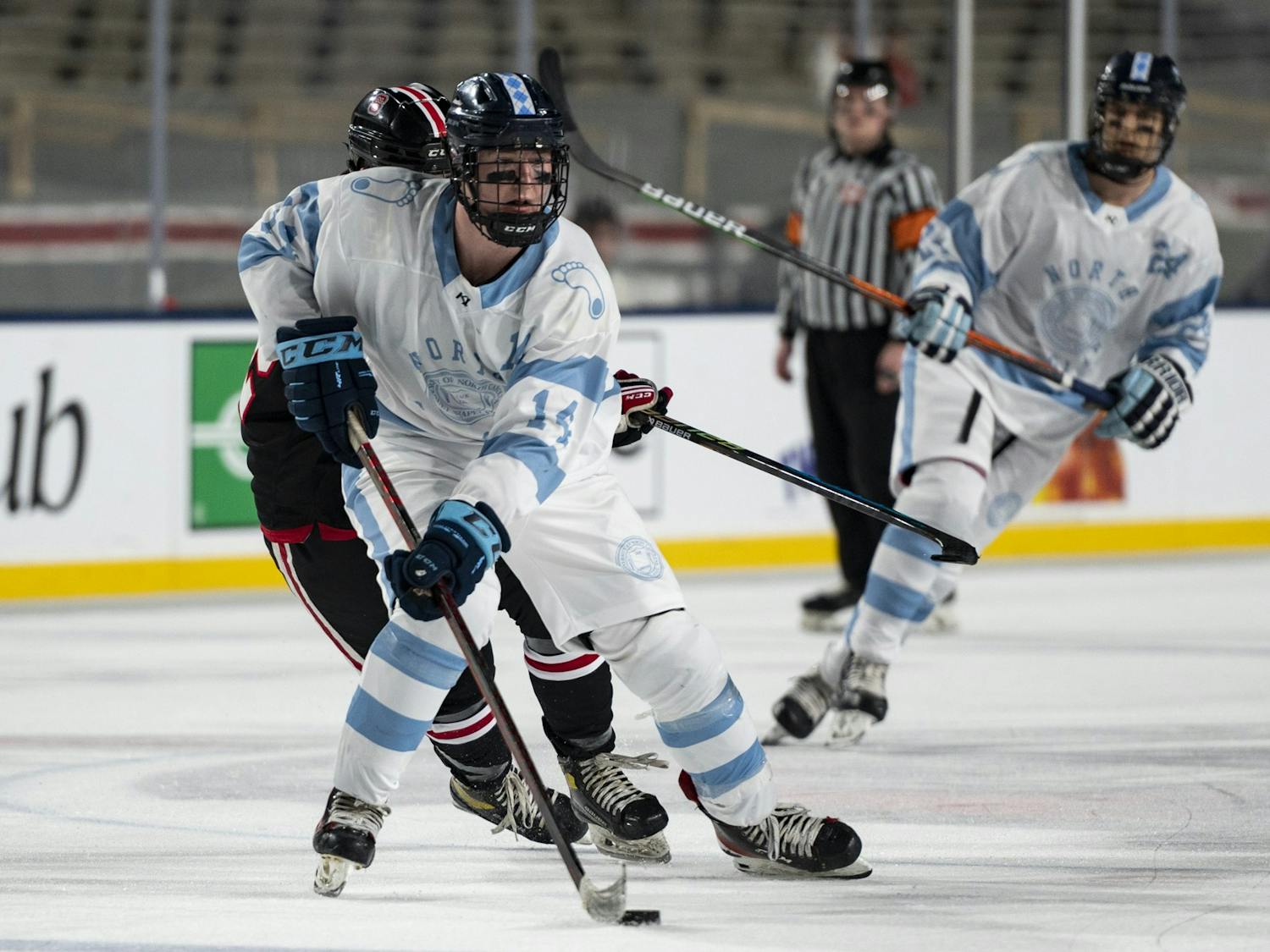UNC forward Patrick O'Shaughnessy (14) transitions the puck across the rink during the ice hockey game against N.C. State at Carter-Finley Stadium on Monday, Feb. 20, 2023. UNC lost 3-7.