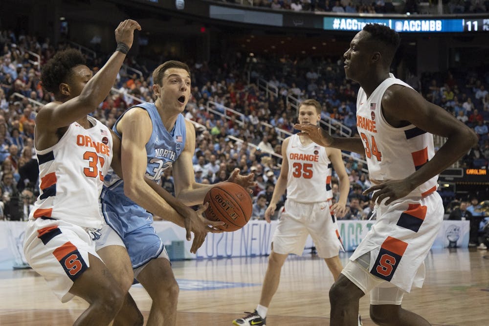UNC graduate forward Justin Pierce (32) fights for possession of the ball against Syracuse in the second round of the 2020 New York Life ACC Tournament held in the Greensboro Coliseum in Greensboro, N.C., on Wednesday, March 11, 2020. UNC lost 81-53.