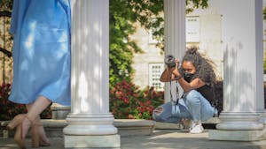 Hanna Wondmagegn, a UNC senior journalism major, takes graduation pictures of Deanna Upchurch, a senior peace, war and defense major at the Old Well.
