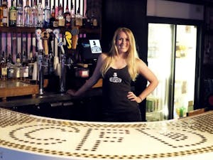 Lauren Fortkort, a co-owner of the new country bar on Rosemary Street, poses behind one of the bar’s counters. Country Fried Duck offers three bars and a patio.