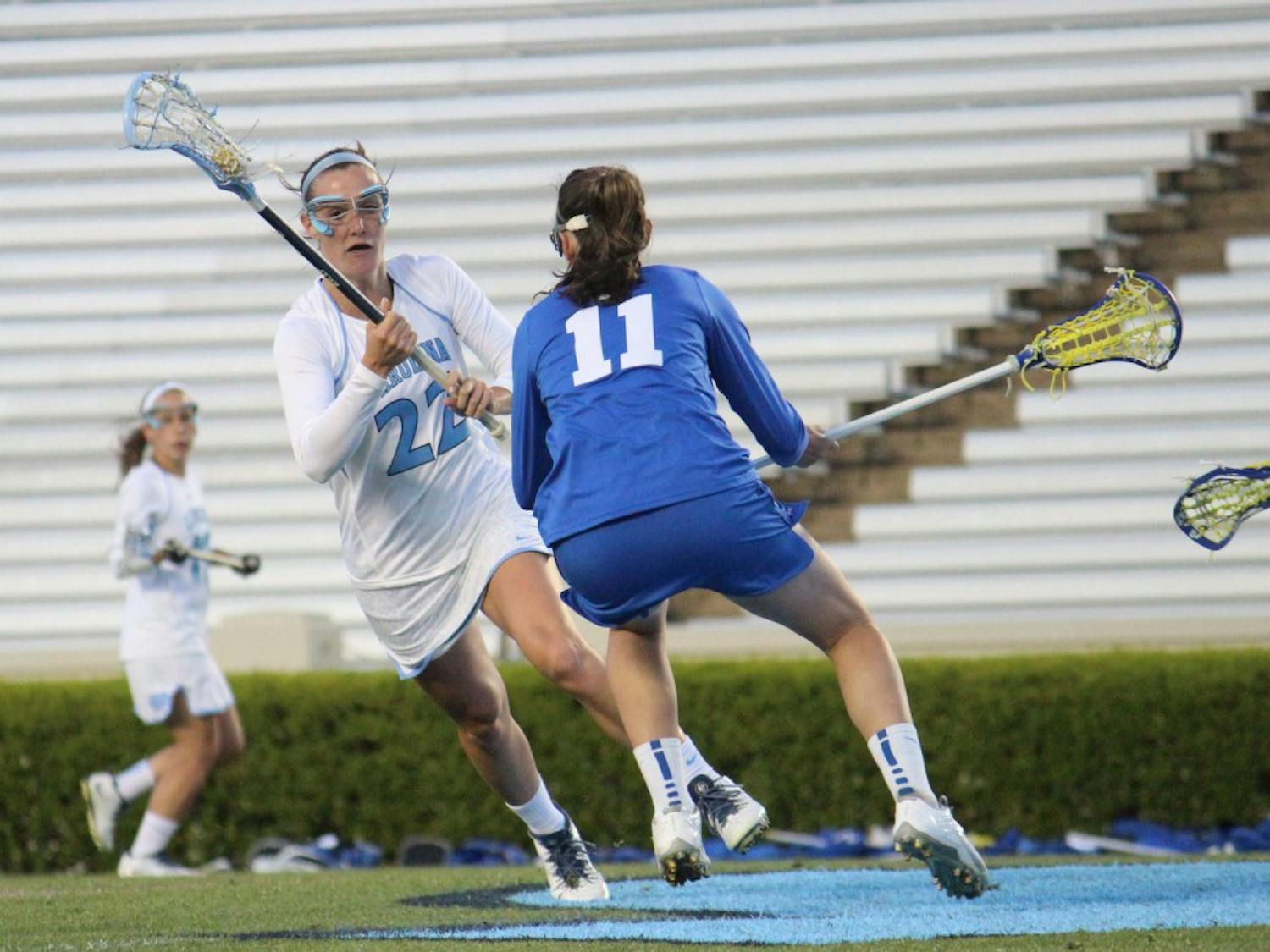 Women's lacrosse suffers a loss 7-6 to Duke in overtime on Wednesday in Kenan Stadium. Number 22 midfielder Maggie Bill dodges a Duke player during the first half. 