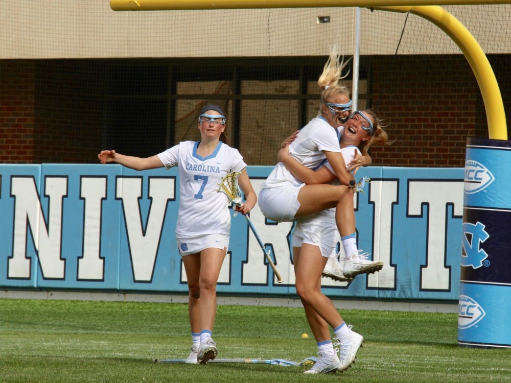 <p>Katie Hoeg (8) leaps into the arms of attacker Jamie Ortega (3), who scored the game-winning goal against Maryland on Feb. 24 in Kenan Stadium.</p>