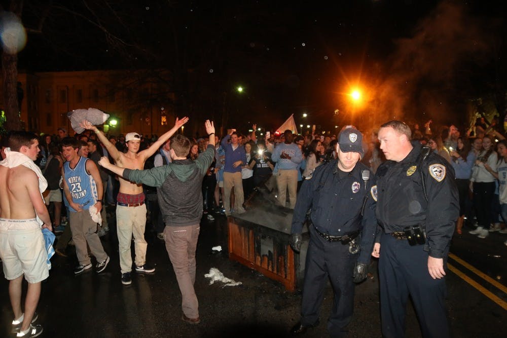 <p>Law enforcement officers put out bonfires on Franklin Street after North Carolina's 76-72 victory over Duke on March 5, 2016.</p>
