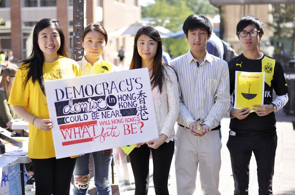 From left to right, Sam Lin, Kathleen Cheng, Christie Leung, Tim Kang, and Kiko Wong stand together to support Hong Kong, sponsored by the Asian Students Association at UNC. Christie and Kiko are students from Hong Kong studying at UNC through the GLOBE program, Sam and Tim are students at UNC and members of the Asian Students Association, and Kathleen graduated from UNC with the Class of 2014.
