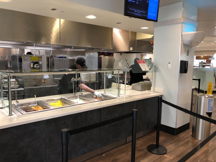 A Carolina Dining Services worker attends to food in the Chase Dining Hall on Tuesday, March 17, 2020. 