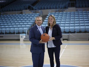 Courtney Banghart, the newly hired UNC women's basketball head coach, poses with athletic director Bubba Cunningham at a small press conference in Carmichael Arena about her hopes for the program on May 1, 2019.