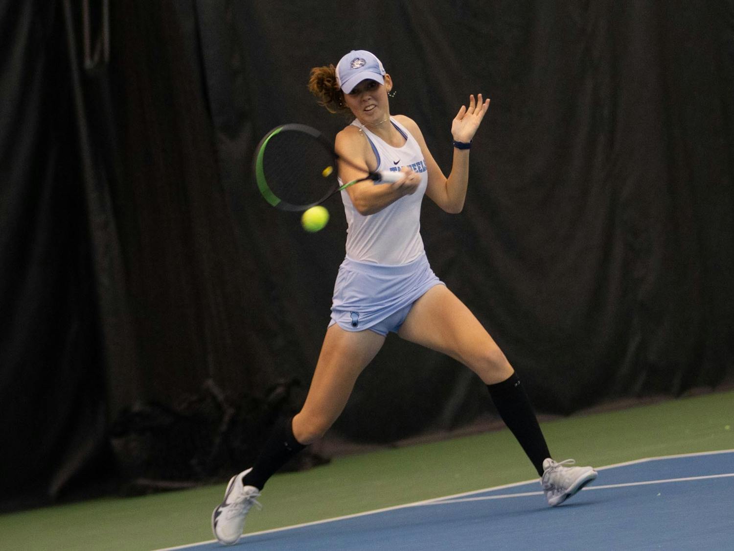 UNC junior Elizabeth Scotty strikes the ball against UNC Charlotte at the Cone-Kenfield Tennis Center Indoor Courts on Friday, Jan. 28, 2022. UNC won 4-0.
