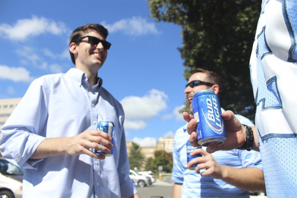 Tailgating: Trent Womble (left) from Raleigh and John Russell from Cary (right) enjoy a beer with friends