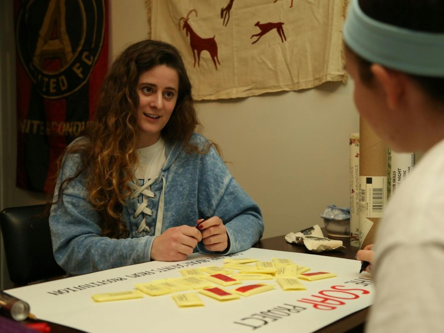 (From left to right) Kara Cody, a senior exercise and sport science and psychology major, and Jaycee Reilly, a senior exercise and sports science and romance languages double major, prepare a poster board on Tuesday, February 5, 2019 for the SOAP project event on Friday, February 8, 2019 in the Pit. The SOAP project raises awareness about human trafficking. The event will encourage students to place labels with a human trafficking hotline on bars of soap. The soaps are then placed in hotels to help victims get help.  
