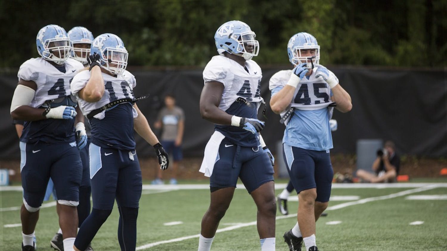 Tarheel Junior Gnonkonde, center, lines up to run through a play during practice on Tuesday, August 25, 2015.